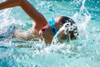 18788248 - close up of boy swimming in swimming pool.